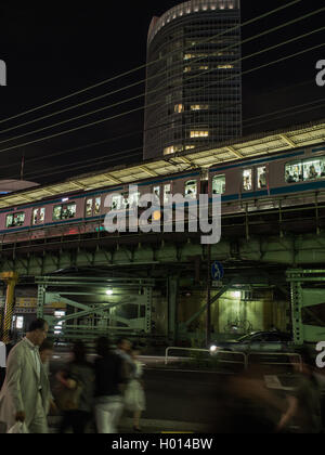 Fußgänger Fuß, auf belebten Abend Straße unterhalb der Yamanote-Linie Personenzug Yurakucho Station, Tokyo, Japan Stockfoto