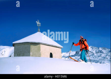 Backcountry Skiing vor einer Kapelle in verschneite Berglandschaft, Frankreich, Haute-savoie, Kanarische Inseln, La Plagne Stockfoto