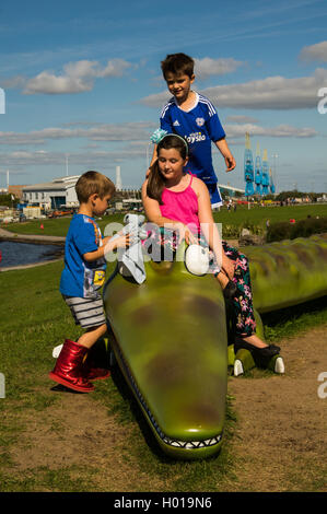 Kinder spielen auf Roald Dahls die enorme Krokodil an Cardiff Bay Talsperre. Stockfoto