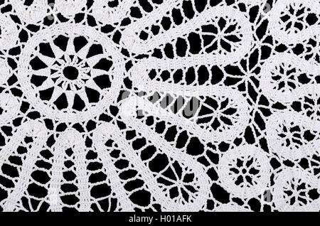 Stern und Kreise in eine weiße gehäkelte Deckchen. Häkeln ist ein Prozess der Schaffung Stoff durch Verzahnung Schleifen des Garns. Stockfoto