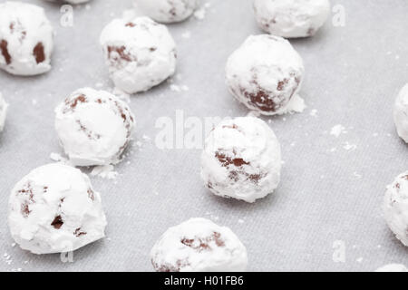 Macht Schokolade Cookies - Chokolade Teigkugeln in Puderzucker auf Backblech abgedeckt Stockfoto