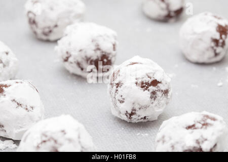 Macht Schokolade Cookies - Chokolade Teigkugeln in Puderzucker auf Backblech abgedeckt Stockfoto