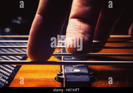 Männliche Finger, die fünf Saiten spielen jazz Bass-Gitarre. Stockfoto