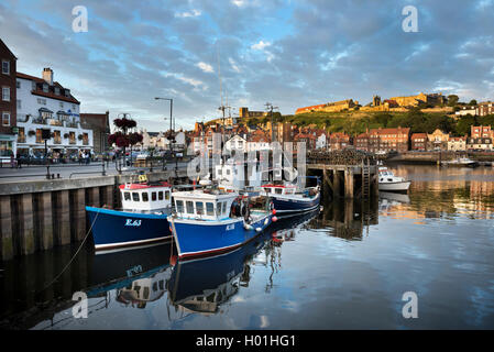 Der Hafen, Whitby, North Yorkshire, UK. Die Abtei und Str. Marys Kirche werden oben auf den Klippen oben gesehen. Stockfoto