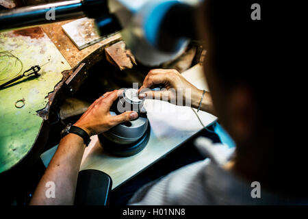 Professionelles Arbeiten auf einem Stück Metall ein optisches Gerät mit Juwelier Stockfoto