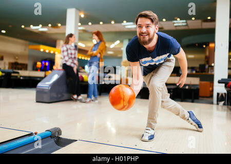 Gut aussehender Mann wirft Bowling ball Stockfoto