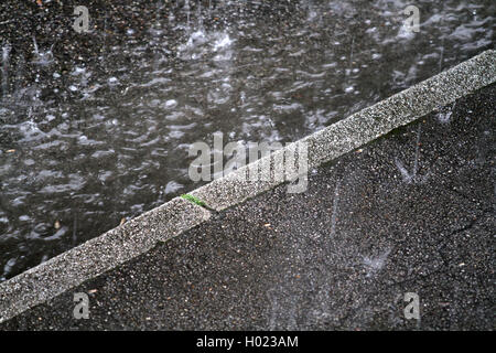 Heavy Rain auf Bürgersteig laufen auf der Straße Dachrinne, Deutschland, Nordrhein-Westfalen Stockfoto