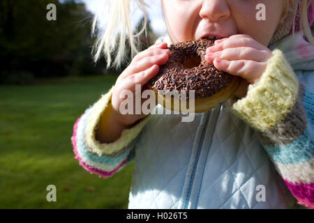 Mädchen über Essen und Naschen auf ungesunde Lebensmittel Stockfoto