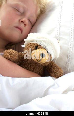 Ein junges Mädchen, schlecht im Bett kuscheln den Teddy, fühlt sich auch schlecht. Stockfoto