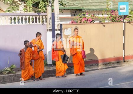 UNAWATUNA, SRI LANKA - 6. März 2014: Gruppe von buddhistischen Mönchen in traditionellen orangefarbene Gewänder Bus am Bahnhof warten. 4km landeinwärts her Stockfoto