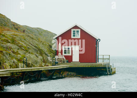 Tjorn, Schweden - 9. September 2016: Ökologische Dokumentation der roten und weißen Küste Haus in nebligen Landschaft. Stockfoto