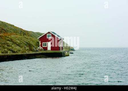 Tjorn, Schweden - 9. September 2016: Ökologische Dokumentation der roten und weißen Küste Haus in nebligen Landschaft. Stockfoto