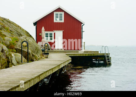 Tjorn, Schweden - 9. September 2016: Ökologische Dokumentation der roten und weißen Küste Haus in nebligen Landschaft. Stockfoto