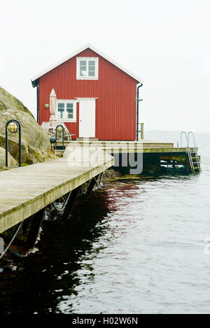 Tjorn, Schweden - 9. September 2016: Ökologische Dokumentation der roten und weißen Küste Haus in nebligen Landschaft. Stockfoto