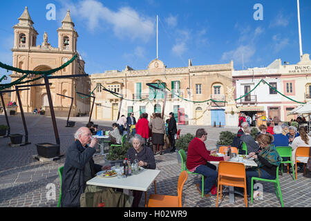 MARSAXLOKK, MALTA - 11. Januar 2015: Menschen Essen im Restaurantterrasse vor der Pfarrei Kirche der Madonna von Pompeji. Stockfoto