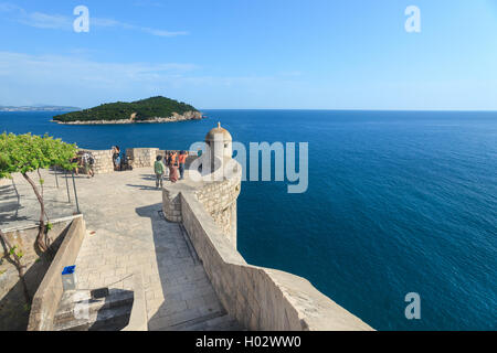 DUBROVNIK, Kroatien - 26. Mai 2014: Tourist am alten Stadtmauern mit Insel Lokrum und Adriatischen Meer im Hintergrund. Alte Mauer gehört zu Stockfoto