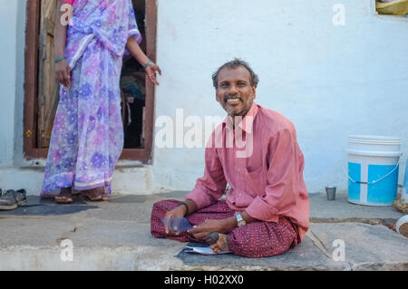 KAMALAPURAM, Indien - 2. Februar 2015: indische Mann sitzt in einer Stadt in der Nähe von Hampi vor Haus Stockfoto