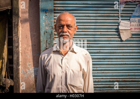 VARANASI, Indien - 20. Februar 2015: älterer Mann mit weißem Bart in der Straße neben dem steht indischen Laden geschlossen. Stockfoto