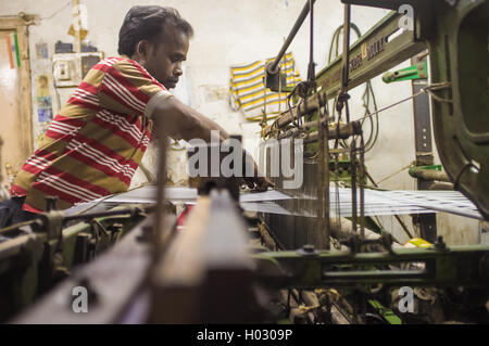 VARANASI, Indien - 21. Februar 2015: Arbeiter Reparaturen Textilmaschine in kleinen Fabrik. Stockfoto