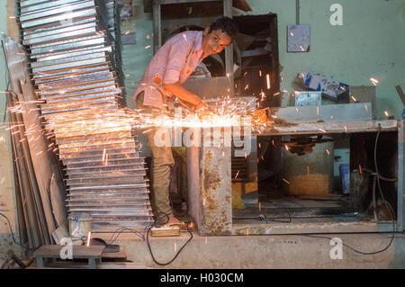 JODHPUR, Indien - 10. Februar 2015: junger Arbeiter schärft Metallteil und Funken macht. Stockfoto