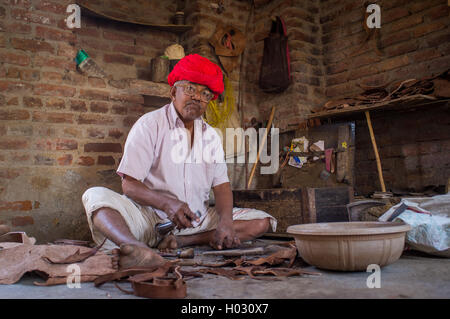 GODWAR REGION, Indien - 13. Februar 2015: ältere indische Schuhmacher aus Rabari Stamm macht neues paar traditionelle Schuhe in Werken Stockfoto