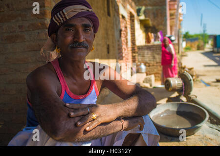 GODWAR REGION, Indien - 14. Februar 2015: Mechaniker mit Schnurrbart tragen Kopftuch und große goldene Ohrringe sitzt außerhalb Worksho Stockfoto