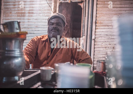 JODHPUR, Indien - 11. Februar 2015: indischer Milchtee Verkauf Mann sitzt in Front des Shops. Nachbearbeitet mit Maserung und Textur. Stockfoto