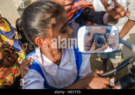 HAMPI, Indien - 1. Februar 2015: indische Kinder Motorrad herumspielen und Fotograf im Rückspiegel zu betrachten Stockfoto