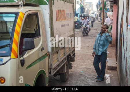 MUMBAI, Indien - 12. Januar 2015: indischer Mann steht neben Lkw im Slum Dharavi und Gespräche über Handy. Dharavi ist eines der l Stockfoto