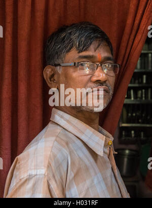 MUMBAI, Indien - 12. Januar 2015: ältere indische Mann mit Brille und Bindi steht in Tür des Hauses. Stockfoto