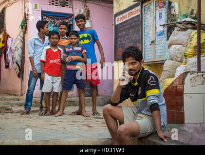 MUMBAI, Indien - 16. Januar 2015: fünf Jungs stehen gemeinsam im Slum Straße während der ältere junge Gespräche über Handy. Stockfoto