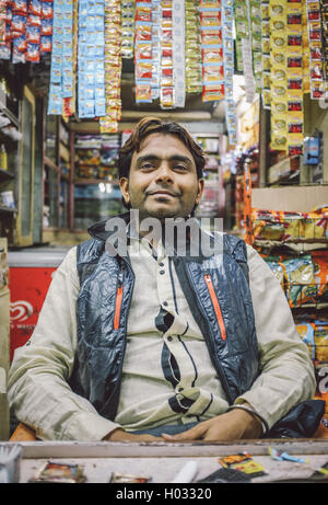 MUMBAI, Indien - 5. Februar 2015: indische Hersteller sitzt im Shop mit Gutka hängen im Hintergrund. Nachbearbeitet mit Korn, textur Stockfoto