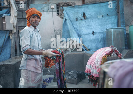 MUMBAI, Indien - 10. Januar 2015: indische Arbeiter einen Sari in Dhobi Ghat waschen. Nachbearbeitet mit Getreide, Textur und Farbe effektiver Stockfoto