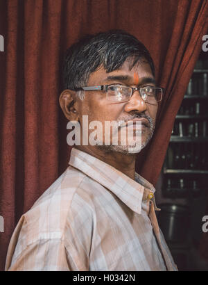 MUMBAI, Indien - 12. Januar 2015: ältere indische Mann mit Brille und Bindi steht in Tür des Hauses. Nachbearbeitet mit Getreide, Stockfoto