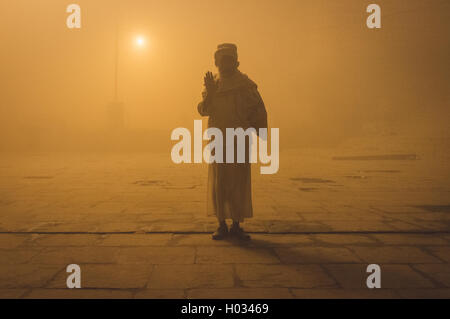 VARANASI, Indien - 20. Februar 2015: Pilger grüßt auf Varanasi Ghat am nebligen Morgen. Nachbearbeitet mit Getreide, Textur und co Stockfoto