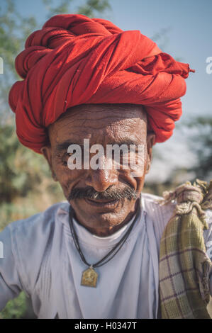 GODWAR REGION, Indien - 14. Februar 2015: ältere Rabari Stammesangehörige mit roten Turban. Nachbearbeitet mit Getreide, Textur und Farbe Stockfoto
