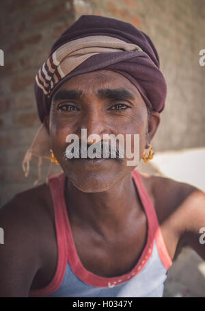 GODWAR REGION, Indien - 14. Februar 2015: Mechaniker mit Schnurrbart tragen Kopftuch und große goldene Ohrringe sitzt außerhalb Worksho Stockfoto