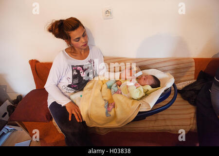 ZAGREB, Kroatien - 12. November 2013: Roma Mutter Flasche füttern Babys in ihrem Haus. Stockfoto