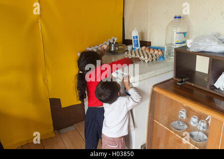 ZAGREB, Kroatien - 21. Oktober 2013: Roma Kinder grabbing Box von Eiern in der Küche. Stockfoto