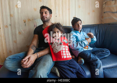 ZAGREB, Kroatien - 21. Oktober 2013: Roma-Mann und seine Kinder zu Hause. Stockfoto