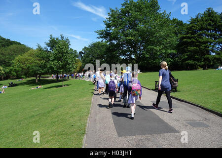 Gruppe von Schulkindern zu Fuß durch den Schlosspark in Colchester, Essex, auf Sommertag Stockfoto