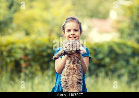 Kleines Mädchen hält Katze Outdor. Eine Katze zu konzentrieren Stockfoto