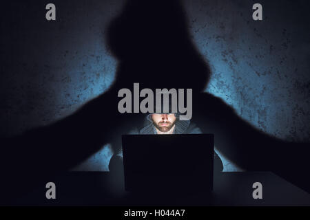 Mann-Hacker arbeitet in dunklen leeren Raum Stockfoto