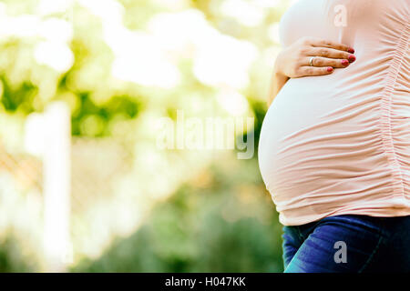 Schöne schwangere Frau Bauch im Freien halten Stockfoto