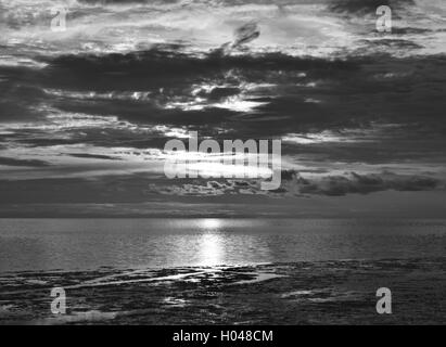 Schwere Wolken bei Sonnenuntergang an einem Strand in Florida. Stockfoto