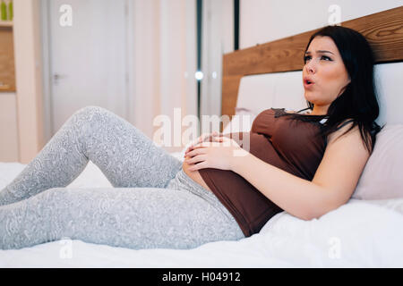 Schwangere Frau vor Schmerzen mit Krämpfen Stockfoto