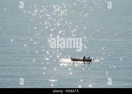 Ein Fischer in einem kleinen Boot bei Sonnenaufgang aus der Insel Paxos, die Ionischen Inseln, die griechischen Inseln, Griechenland, Europa Stockfoto