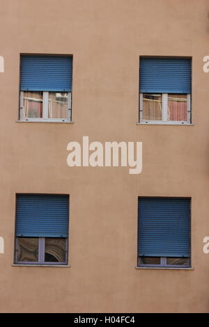 Blaue Fensterläden auf hellen rosa Gebäude, Fensterläden, Gebäude, Wand mit Fenstern, Rom, Roma Stockfoto