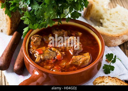 Fleisch-Eintopf in Keramiktopf. Traditionelles ungarisches Gulasch Stockfoto