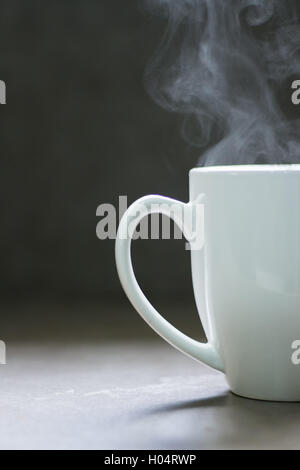Weiße Keramik Tasse mit dampfenden Flüssigkeit Stockfoto